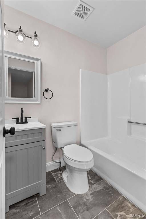 bathroom featuring toilet, vanity, marble finish flooring, and  shower combination