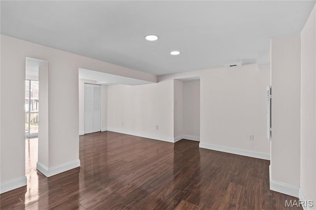 spare room with dark wood-style floors, baseboards, and recessed lighting