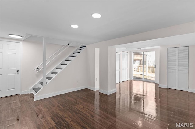 basement featuring baseboards, wood finished floors, stairway, and recessed lighting