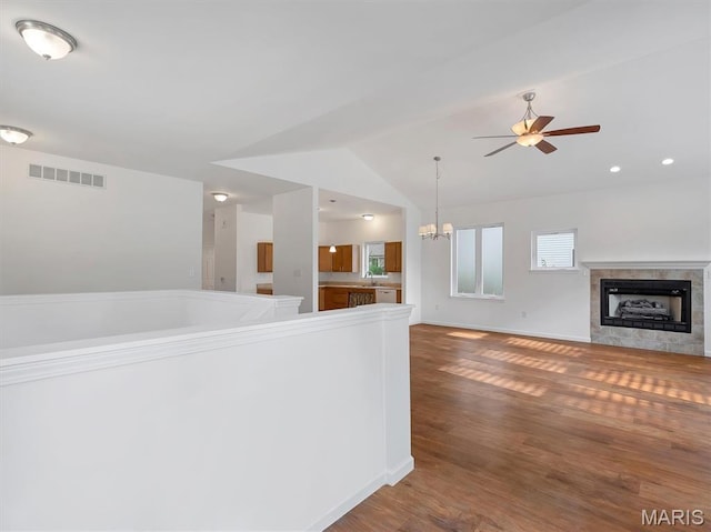 602 S Ballas Rd, Saint Louis, MO 63122 - unfurnished living room featuring ceiling fan, a tiled fireplace, wood finished floors, a chandelier, and vaulted ceiling