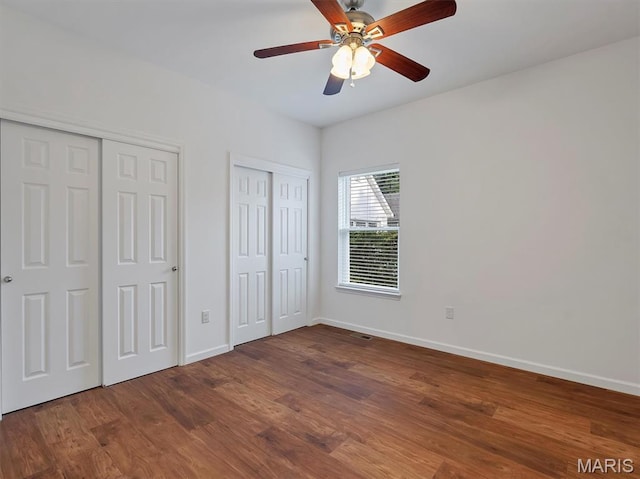 602 S Ballas Rd, Saint Louis, MO 63122 - unfurnished bedroom featuring two closets, wood finished floors, and a ceiling fan