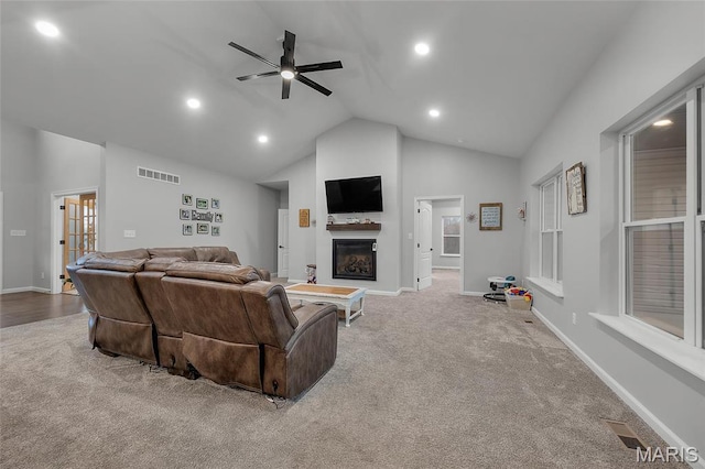 13160 Mammoth Rd, De Soto, MO 63020 - carpeted living area featuring a glass covered fireplace, high vaulted ceiling, a ceiling fan, and recessed lighting
