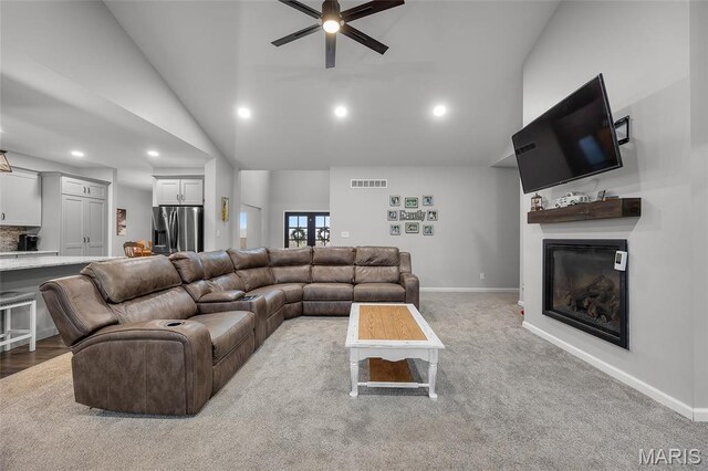 13160 Mammoth Rd, De Soto, MO 63020 - carpeted living room featuring a glass covered fireplace, high vaulted ceiling, a ceiling fan, and recessed lighting