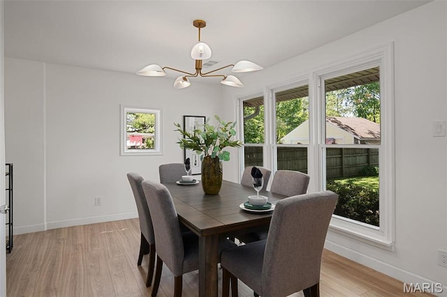dining space with healthy amount of natural light, baseboards, and a chandelier