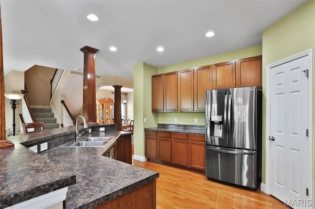 1304 Forest Way, Wentzville, MO 63385 - kitchen featuring stainless steel refrigerator with ice dispenser, ornate columns, a sink, dark countertops, and light wood-type flooring