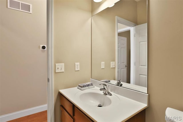 1304 Forest Way, Wentzville, MO 63385 - half bathroom featuring vanity, toilet, wood finished floors, and baseboards