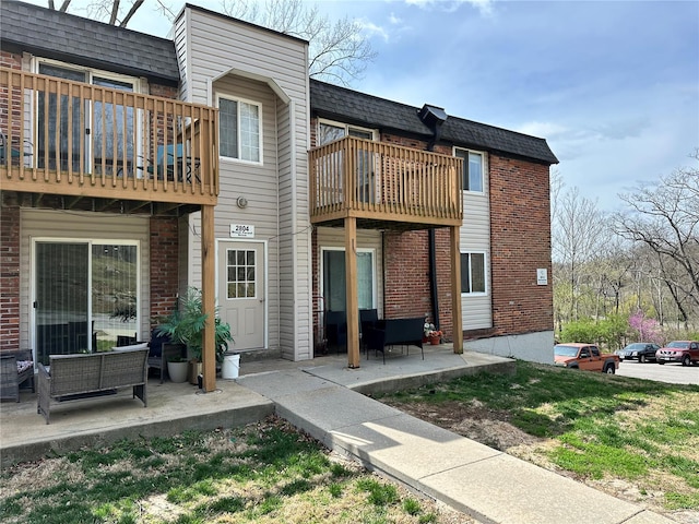 2804 Blackforest Dr Unit A, Saint Louis, MO 63129 - rear view of property featuring a balcony, brick siding, a patio area, outdoor lounge area, and roof with shingles