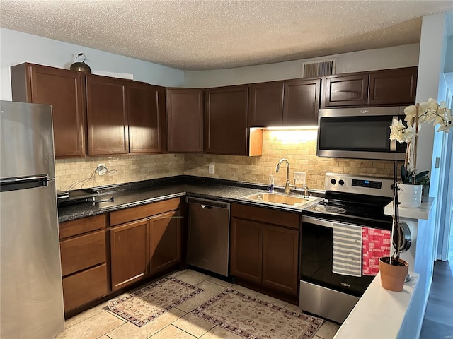 2804 Blackforest Dr Unit A, Saint Louis, MO 63129 - kitchen with appliances with stainless steel finishes, a sink, backsplash, a textured ceiling, and dark countertops