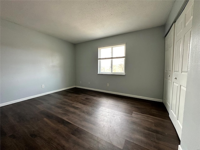 2804 Blackforest Dr Unit A, Saint Louis, MO 63129 - unfurnished bedroom with dark wood-type flooring, a textured ceiling, a closet, and baseboards
