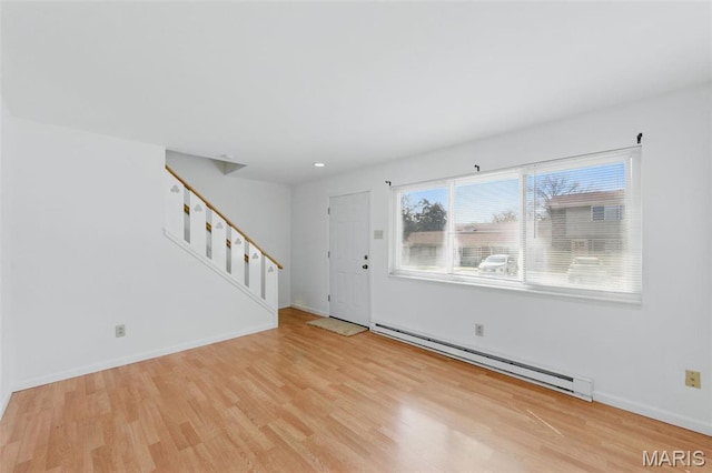 10660 Carroll Wood Way, Saint Louis, MO 63128 - unfurnished living room featuring baseboard heating, light wood-style floors, stairs, baseboards, and recessed lighting