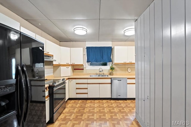 8934 Litzsinger Rd, Saint Louis, MO 63144 - kitchen featuring stainless steel appliances, a sink, light countertops, white cabinets, and under cabinet range hood