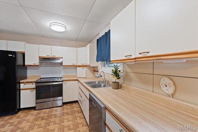 8934 Litzsinger Rd, Saint Louis, MO 63144 - kitchen featuring stainless steel appliances, a sink, under cabinet range hood, and white cabinets