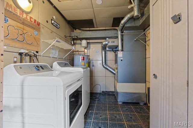 8934 Litzsinger Rd, Saint Louis, MO 63144 - laundry area with independent washer and dryer, electric water heater, and dark tile patterned floors