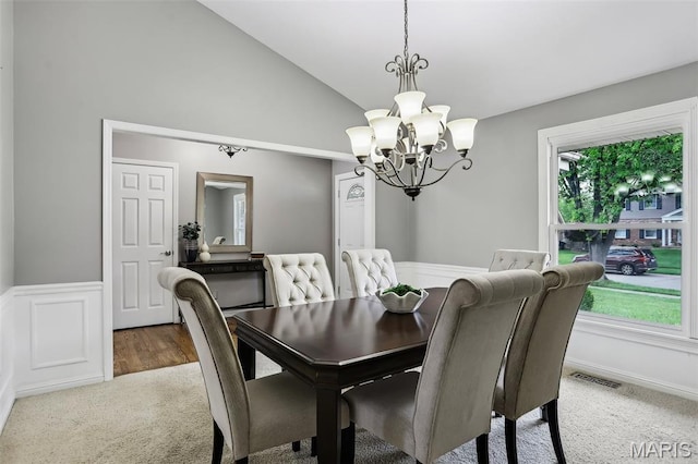 2113 Fairway Bnd, Chesterfield, MO 63017 - dining room featuring a chandelier, carpet, a wainscoted wall, high vaulted ceiling, and a decorative wall