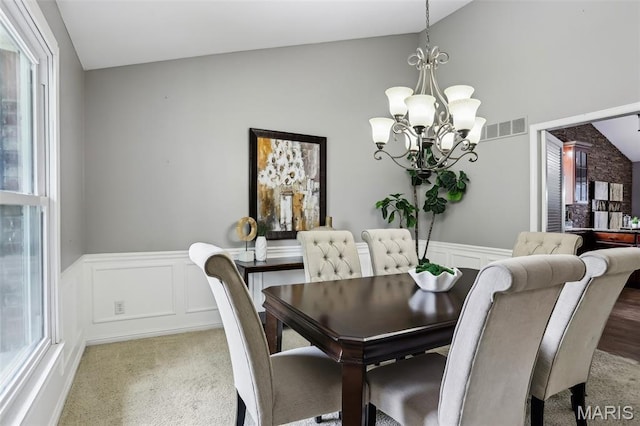 2113 Fairway Bnd, Chesterfield, MO 63017 - dining area with vaulted ceiling, a chandelier, wainscoting, and a decorative wall