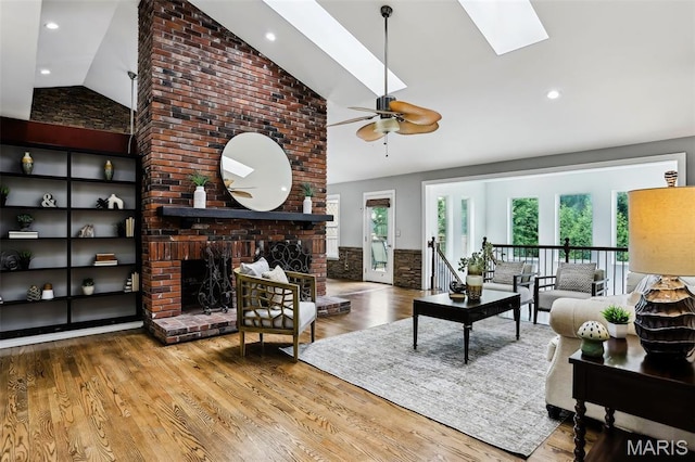 2113 Fairway Bnd, Chesterfield, MO 63017 - living area featuring a skylight, high vaulted ceiling, a brick fireplace, a ceiling fan, and wood finished floors