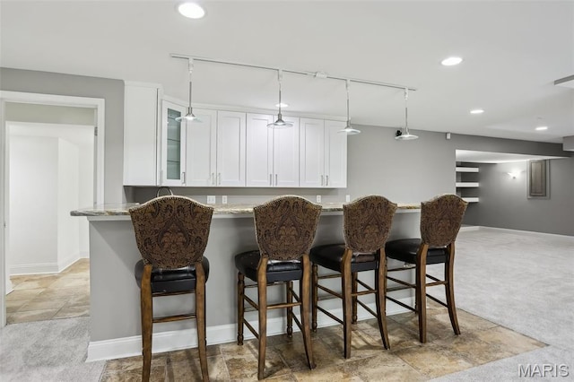 2113 Fairway Bnd, Chesterfield, MO 63017 - kitchen featuring track lighting, white cabinetry, light stone counters, glass insert cabinets, and recessed lighting