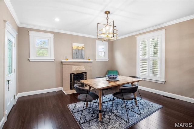 2521 High School Dr, Saint Louis, MO 63144 - dining area with baseboards, a fireplace, crown molding, healthy amount of natural light, and dark wood-style flooring