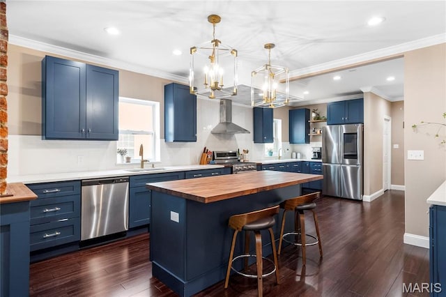2521 High School Dr, Saint Louis, MO 63144 - kitchen with appliances with stainless steel finishes, butcher block counters, blue cabinetry, wall chimney range hood, and a sink