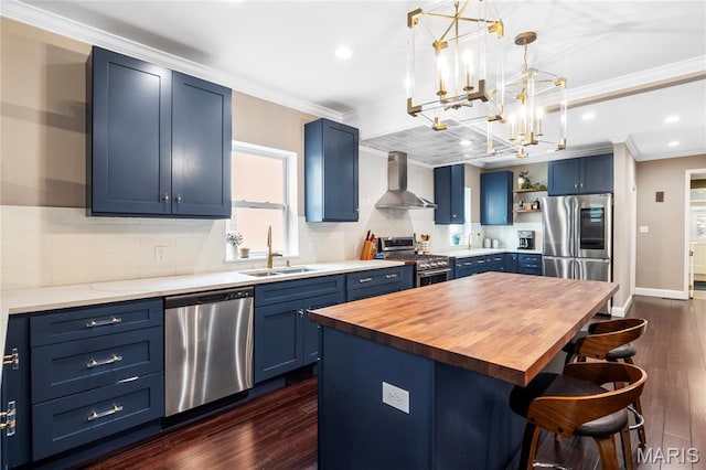 2521 High School Dr, Saint Louis, MO 63144 - kitchen featuring blue cabinetry, appliances with stainless steel finishes, wall chimney exhaust hood, a sink, and ornamental molding