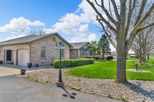 8620 State Route 163, Belleville, IL 62223 - view of side of home with concrete driveway, brick siding, an attached garage, a yard, and roof with shingles