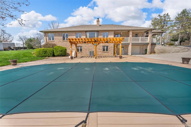 8620 State Route 163, Belleville, IL 62223 - back of property with a pergola, a covered pool, a chimney, brick siding, and central air condition unit