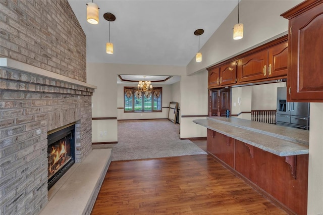 8620 State Route 163, Belleville, IL 62223 - kitchen with a chandelier, a kitchen bar, light countertops, a brick fireplace, and pendant lighting