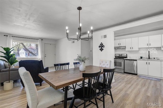 35 Florissant Park Dr, Florissant, MO 63031 - dining space with light wood-style floors and a chandelier