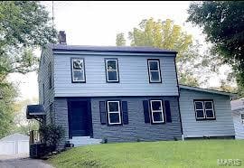 24 Creston Dr, Belleville, IL 62223 - view of front of home with a front lawn, a chimney, a garage, and an outdoor structure