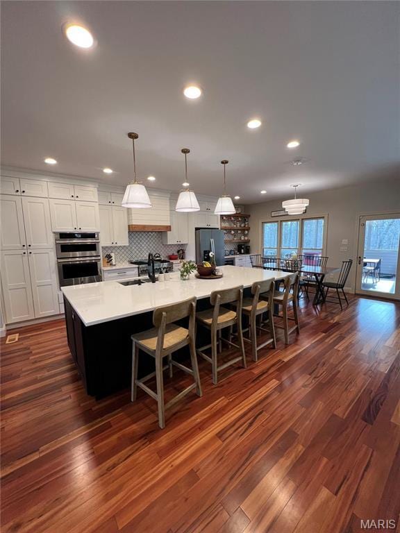 kitchen featuring stainless steel appliances, dark wood-style flooring, light countertops, white cabinetry, and recessed lighting