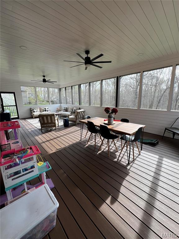 sunroom featuring an outdoor hangout area, plenty of natural light, outdoor dining area, and a ceiling fan