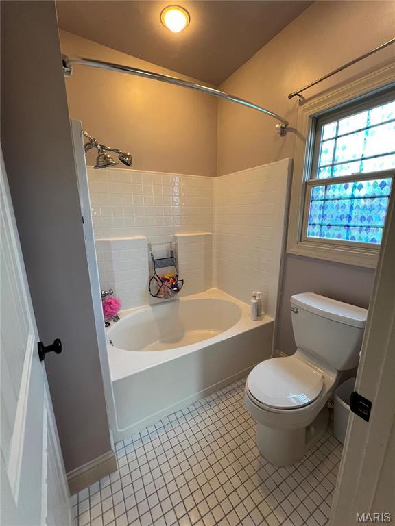 full bath with toilet, tile patterned floors, and shower / washtub combination