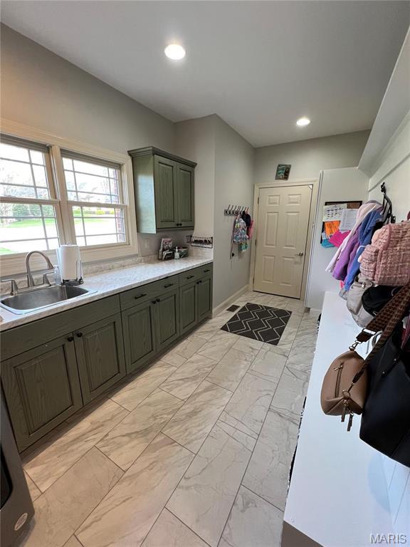 laundry room featuring a sink, light marble finish floors, recessed lighting, and baseboards