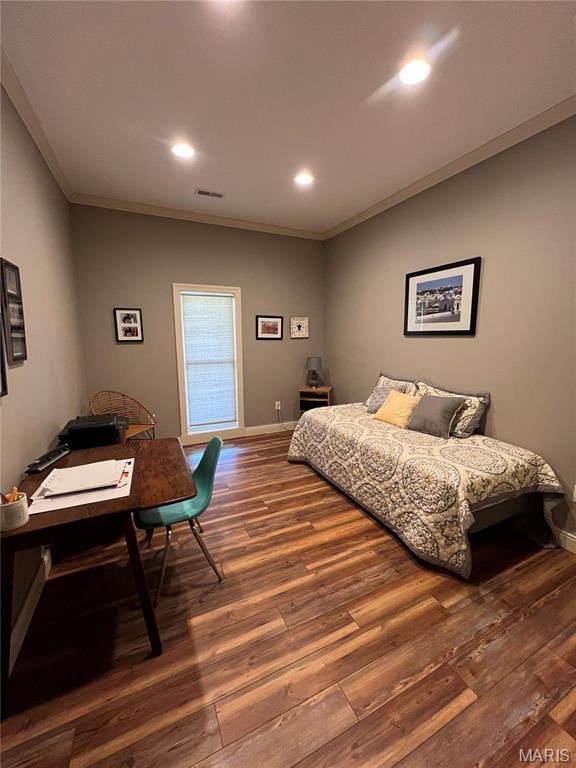 bedroom with wood finished floors, ornamental molding, recessed lighting, and baseboards