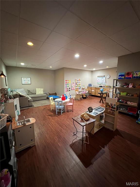recreation room featuring wood finished floors and a drop ceiling