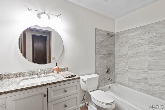 bathroom featuring toilet, vanity, and  shower combination