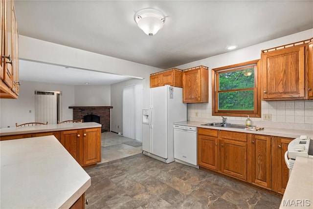 kitchen featuring white appliances, light countertops, brown cabinets, and decorative backsplash