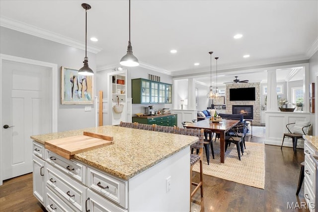 17 Denver Pl, Saint Louis, MO 63119 - kitchen with a stone fireplace, crown molding, dark wood-style floors, white cabinets, and recessed lighting