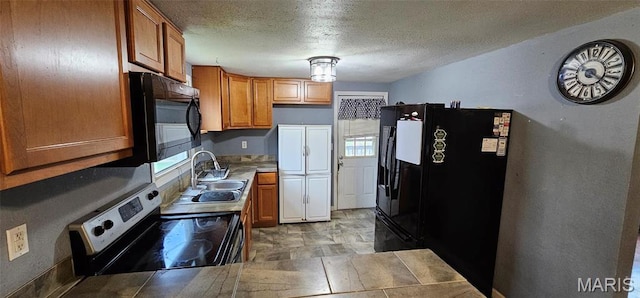 12753 Hencher Rd, De Soto, MO 63020 - kitchen with black refrigerator with ice dispenser, stainless steel electric stove, a sink, brown cabinets, and a textured ceiling