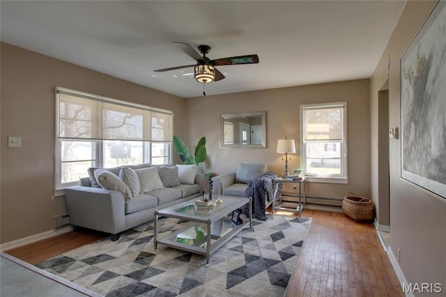 902 E Morgan St, Edina, MO 63537 - living room with a baseboard heating unit, ceiling fan, hardwood / wood-style flooring, and baseboards