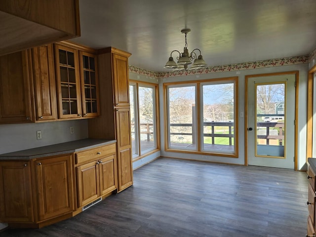 1501 S Main St, Hillsboro, IL 62049 - kitchen featuring a chandelier, dark wood finished floors, glass insert cabinets, dark countertops, and brown cabinets