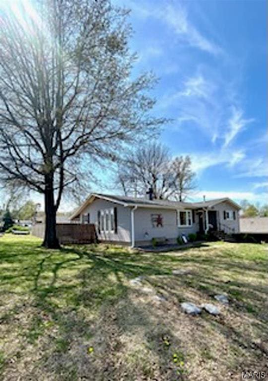 rear view of property with a lawn