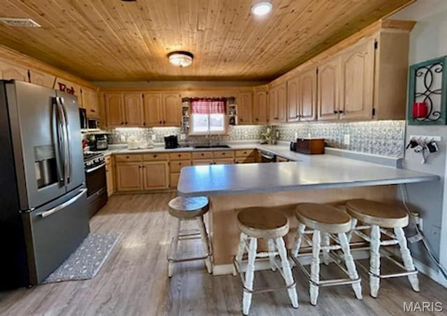 kitchen with appliances with stainless steel finishes, wood ceiling, a peninsula, light wood-type flooring, and a breakfast bar area