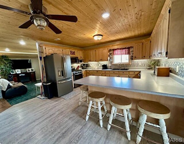 kitchen featuring a sink, appliances with stainless steel finishes, wooden ceiling, a peninsula, and light wood-style floors