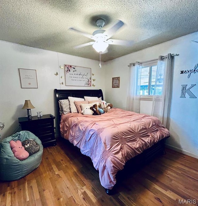 bedroom with wood finished floors, a textured ceiling, and a ceiling fan