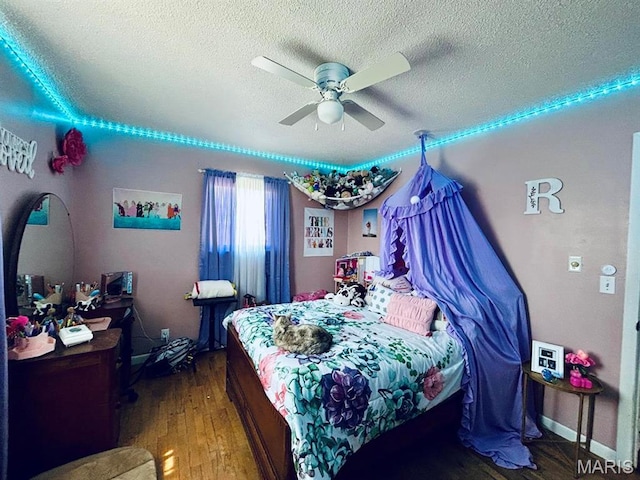 bedroom featuring a textured ceiling, wood finished floors, and ceiling fan
