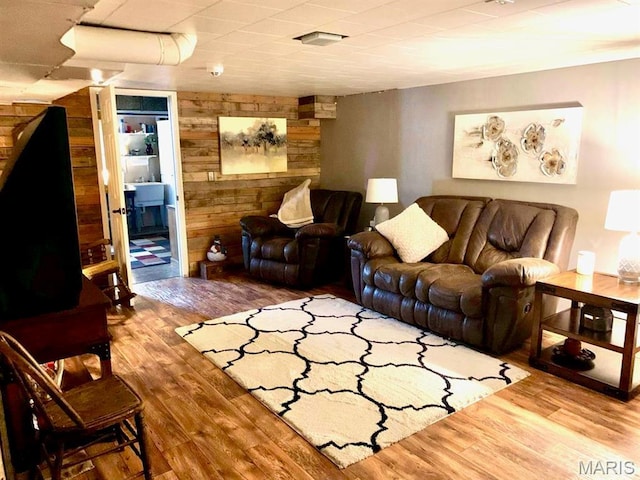 living area featuring wooden walls and wood finished floors