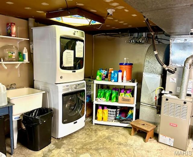 laundry room with stacked washer and clothes dryer and heating unit