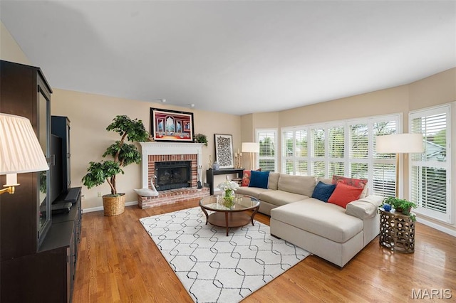 1114 Lockett Rd, Des Peres, MO 63131 - living area featuring a fireplace, light wood-style flooring, and baseboards