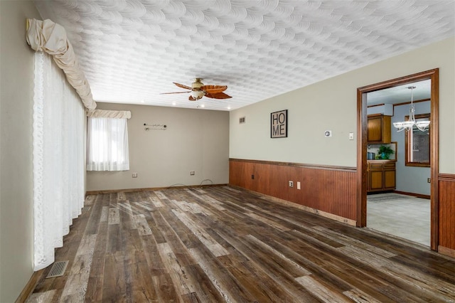 132 S Duncan St, Marine, IL 62061 - unfurnished room featuring dark wood finished floors, a ceiling fan, wainscoting, a chandelier, and wooden walls